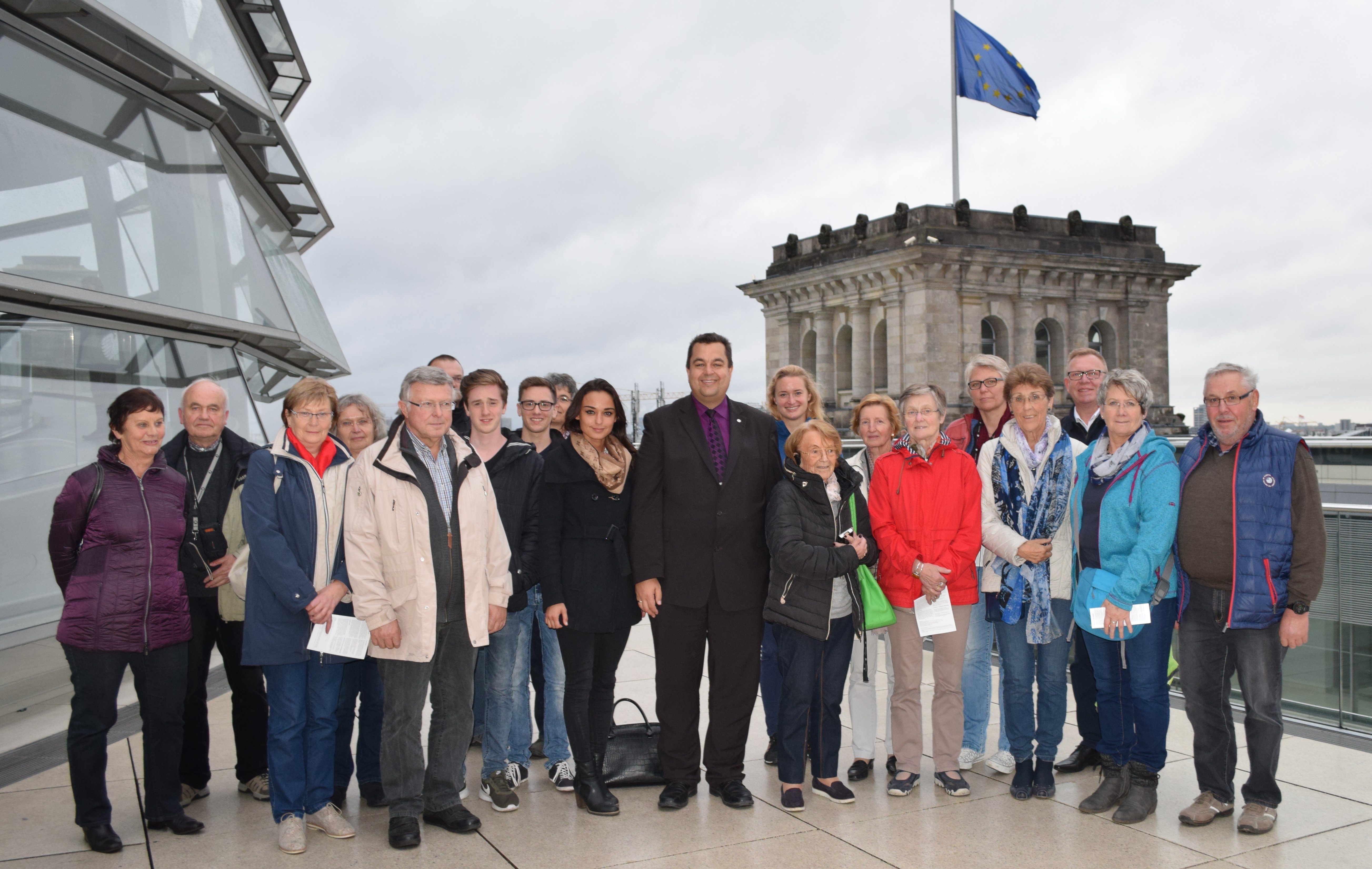 Thomas Viesehon (im dunklen Anzug in der ersten Reihe) den aus Bad Wildungen stammenden Teilnehmern seiner Besuchergruppe auf der Dachterrasse des Reichstagsgebäudes.